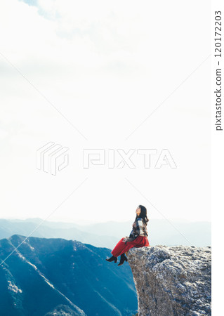 A woman sitting on the fire rocks of Oishi Plateau A woman sitting on the fire rocks of Oishi Plateau 120172203