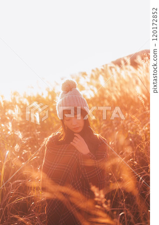 一個女人被夕陽染上的潘帕斯草包圍 120172852