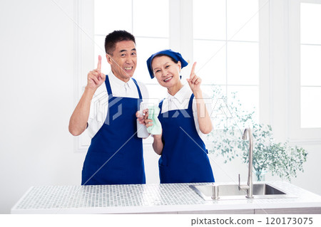 穿著藍色圍裙和白色 Polo 衫的高級管家（男性和女性、丈夫和妻子）在廚房排隊 120173075