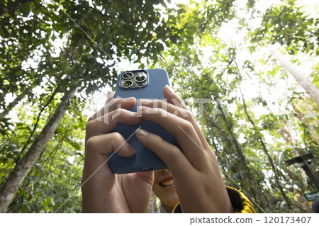Child taking a photo in the woods 120173407