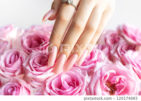 Woman showing stylish pink manicure on bouquet of roses Woman showing stylish pink manicure on bouquet of roses 120174065