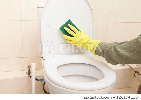 Home Cleaning in protective Yellow gloves, green sponge. Cleans Toilet with Household Chemicals. Toilet cleaning, Disinfection and Hygiene Eco Concept 120174110