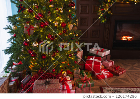 Classical Christmas decorated interior living room with fireplace. Christmas tree with red golden ornament decorations gift boxes. Modern classic style interior design apartment. Christmas eve at home Classical Christmas decorated interior living room with fireplace. Christmas tree with red golden ornament decorations gift boxes. Modern classic style interior design apartment. Christmas eve at home 120174286