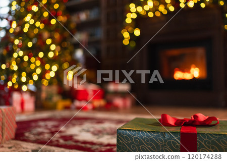 Green gift box in classical Christmas decorated interior living room library with fireplace. Christmas gift near fir tree on Christmas eve. Modern classic style interior design apartment. Christmas Green gift box in classical Christmas decorated interior living room library with fireplace. Christmas gift near fir tree on Christmas eve. Modern classic style interior design apartment. Christmas 120174288