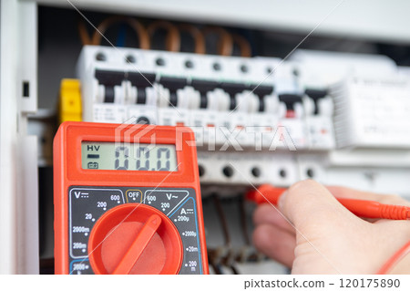 Electrician Measuring Voltage with Multimeter in Circuit Breaker Panel Electrician Measuring Voltage with Multimeter in Circuit Breaker Panel 120175890