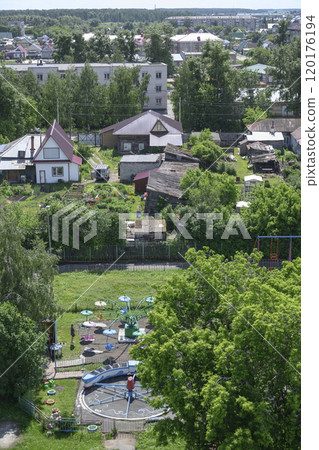 Aerial view of park with a carousel, dense trees, urban and rural houses in Kuibyshev, Russia 120176194