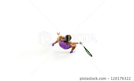 Overhead perspective of tennis player, eyes locked on ball, ready to deliver powerful serve against white studio background. 120176322