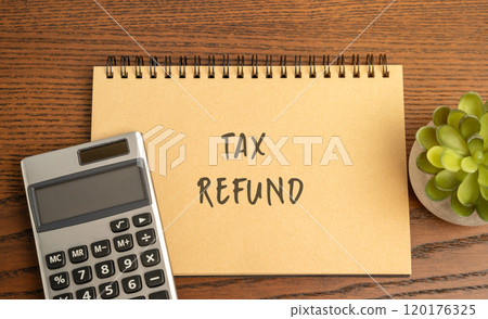 Tax refund concept - return of excess taxes paid to the government by a taxpayer. Business and finance. Notebook with inscription and calculator 120176325
