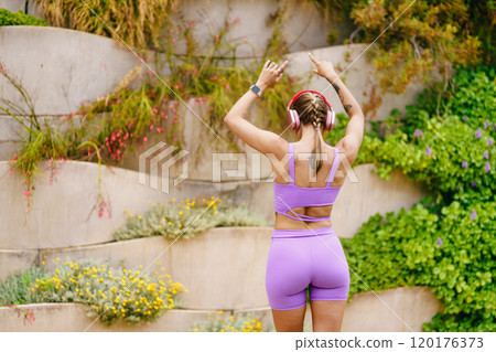 A Fit and Active Woman Dressed in Stylish Purple Workout Gear at a Beautiful Scenic Outdoor Location 120176373