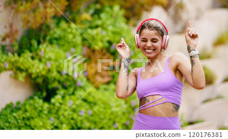 A Joyful Woman Ecstatically Dancing Outdoors While Listening to Music Through Headphones A Joyful Woman Ecstatically Dancing Outdoors While Listening to Music Through Headphones 120176381