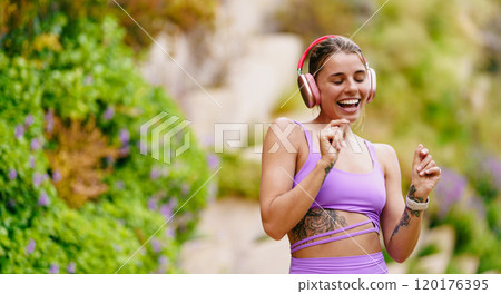 A Joyful Woman Dancing Outdoors with Headphones, Celebrating Life and Movement in Nature A Joyful Woman Dancing Outdoors with Headphones, Celebrating Life and Movement in Nature 120176395
