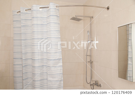 Front view of Modern Bathroom Interior with corner shower curtain. Bathroom interior with chrome faucet 120176409