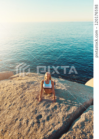 Yoga open the mind to all the beauty. Shot of an athletic young woman practicing yoga on the beach. 120176598