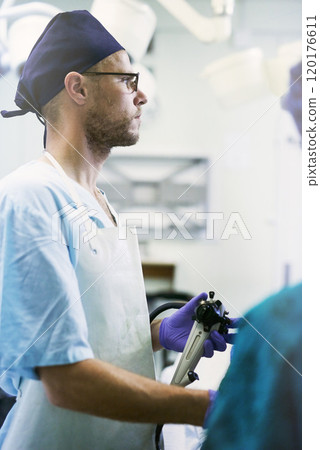 The focus is on saving lives. Shot of a young surgeon performing surgery on a patient in an operating room. The focus is on saving lives. Shot of a young surgeon performing surgery on a patient in an operating room. 120176611