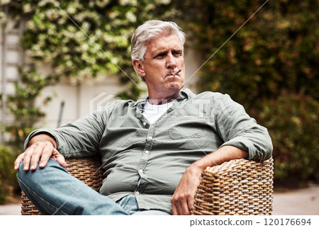 I feel like a king. Cropped shot of a relaxed senior man smoking a marijuana joint on his own inside of his garden at home during the day. I feel like a king. Cropped shot of a relaxed senior man smoking a marijuana joint on his own inside of his garden at home during the day. 120176694