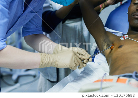 Reducing the risk of infection with preoperative sterilization. Cropped shot of a doctor sterilizing a patients chest in an emergency room. Reducing the risk of infection with preoperative sterilization. Cropped shot of a doctor sterilizing a patients chest in an emergency room. 120176698