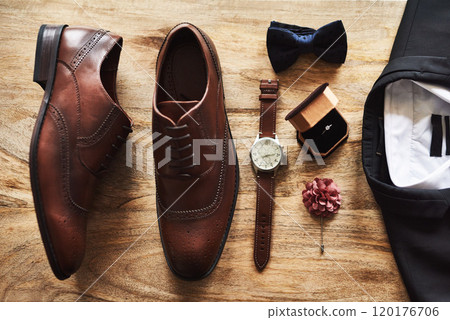 All set for the big day. Still life shot of formal shoes alongside a suit and other accessories on a wooden surface. 120176706