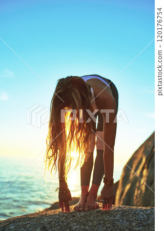 Yoga makes you come alive. Shot of an athletic young woman practicing yoga on the beach. Yoga makes you come alive. Shot of an athletic young woman practicing yoga on the beach. 120176754