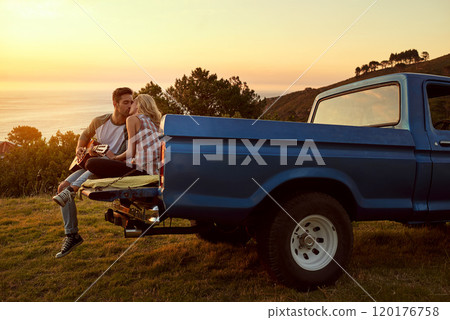 Making beautiful music together. Shot of a young man playing guitar for his girlfriend on a roadtrip. Making beautiful music together. Shot of a young man playing guitar for his girlfriend on a roadtrip. 120176758