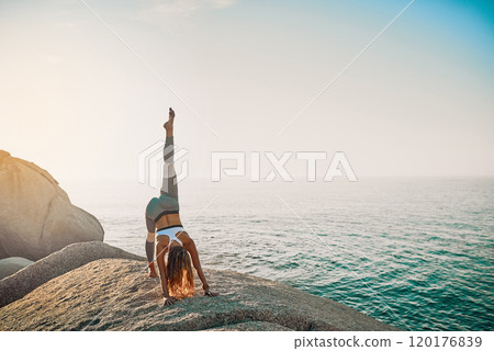 Life is a gift, let it flow. Shot of an athletic young woman practicing yoga on the beach. 120176839