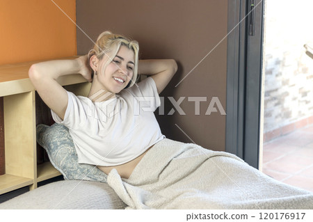 Smiling woman in bed, stretching arms, enjoying a relaxed morning. Smiling woman in bed, stretching arms, enjoying a relaxed morning. 120176917