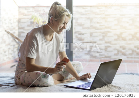 Woman shopping online with a credit card and laptop. 120176923