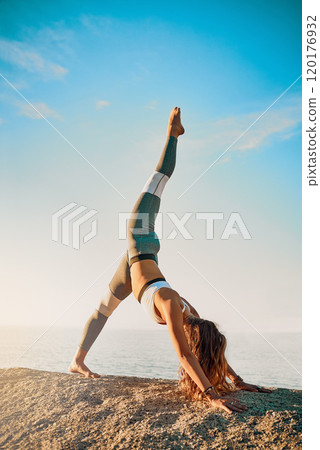 Let today be the start of something new. Shot of an athletic young woman practicing yoga on the beach. Let today be the start of something new. Shot of an athletic young woman practicing yoga on the beach. 120176932