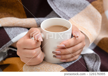 Female hands holding a white mug of coffee Female hands holding a white mug of coffee 120176995