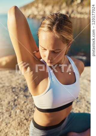 Yoga is so calm yet so energizing. Shot of a young woman doing yoga at the beach. 120177024