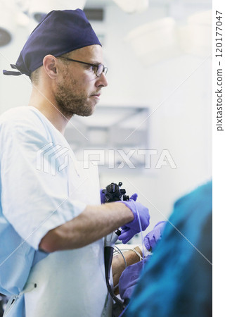 Life saving is what he does. Shot of a young surgeon performing surgery on a patient in an operating room. 120177047