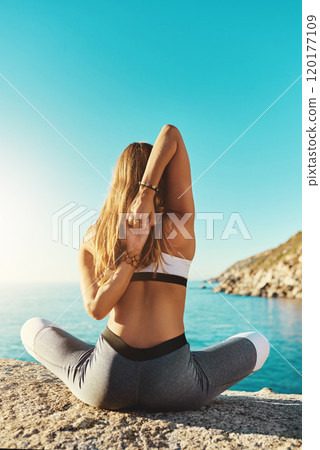 Yoga is for everyone. Rearview shot of a young woman practicing yoga on the beach. Yoga is for everyone. Rearview shot of a young woman practicing yoga on the beach. 120177109