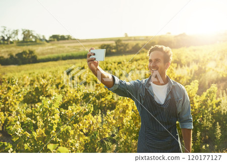 Check out my crops. Shot of a young man taking a selfie with his cellphone while working on a farm. 120177127