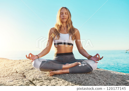 Yoga is the answer. Shot of a young woman doing yoga at the beach. 120177145