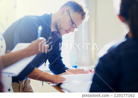 Paperwork is part of the job. Shot of a young doctor filling out paperwork in a hospital. Paperwork is part of the job. Shot of a young doctor filling out paperwork in a hospital. 120177162