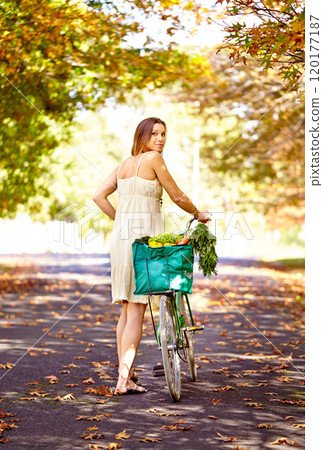 Autumn beauty. Shot of an attractive young woman in the park on an autumn day. 120177187