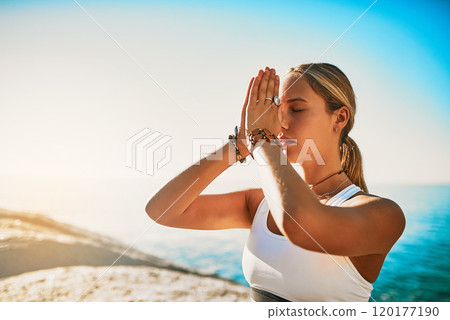 Dont let others destroy your inner peace. Shot of an athletic young woman practicing yoga on the beach. 120177190