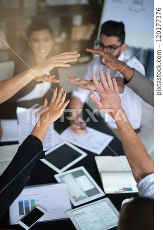 Succeeding is this teams top priority. Shot of a group of coworkers with their hands in a huddle while sitting together around a table in an office. Succeeding is this teams top priority. Shot of a group of coworkers with their hands in a huddle while sitting together around a table in an office. 120177376