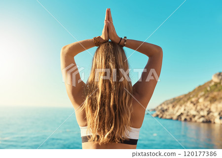 Yoga takes you places youve never been. Rearview shot of a young woman practicing yoga on the beach. 120177386