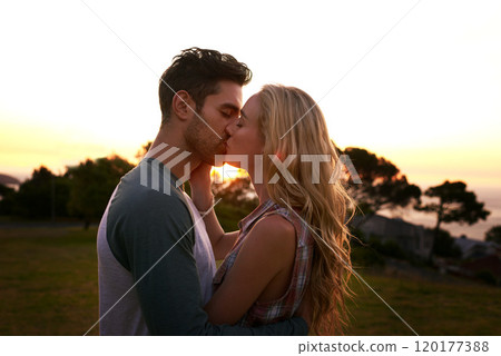 Smooches at sunset. Cropped shot of an affectionate young couple outdoors. 120177388