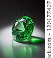 Green emerald gemstone close-up with beautiful light reflections 120177407