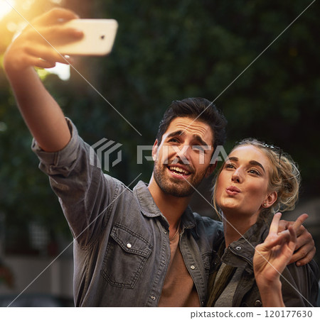 Taking a selfie while out in the city. Shot of a young couple taking a selfie in the city. 120177630