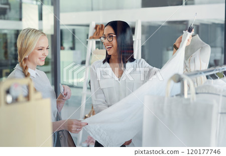 This one is my best-seller. Shot of a sales assistant helping a young woman in a clothing boutique. This one is my best-seller. Shot of a sales assistant helping a young woman in a clothing boutique. 120177746