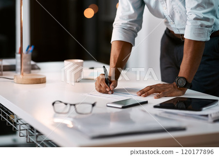 Putting pen to paper on some important issues. Shot of an unrecognizable businessman filling out some paperwork while working late in his office. 120177896