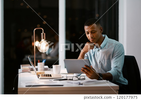 These apps help make my job a little bit easier. Shot of a handsome young businessman using a digital tablet while working late in his office. These apps help make my job a little bit easier. Shot of a handsome young businessman using a digital tablet while working late in his office. 120177975