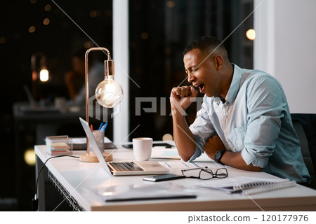 I think its time I went home. Shot of a handsome young businessman yawning and feeling tired while working late in his office. 120177976