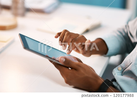 Connecting to the business world. Shot of an unrecognizable businessman using a digital tablet while working late in his office. 120177988