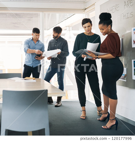 Take note of this awesome team. Shot of a group of businesspeople discussing paperwork during a meeting in a modern office. 120177996