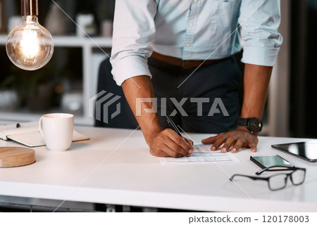 Write your own success story in life. Shot of an unrecognizable businessman filling out some paperwork while working late in his office. 120178003