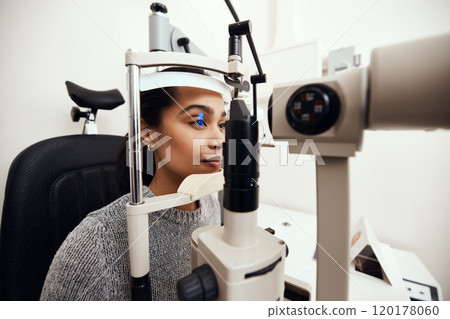 Lets put your sight to the test. Shot of a young woman getting her eyes examined with a slit lamp. Lets put your sight to the test. Shot of a young woman getting her eyes examined with a slit lamp. 120178060