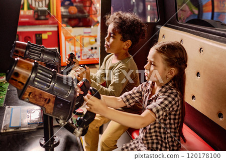 Cute kids in front of game machines Cute kids in front of game machines 120178100